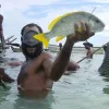 A fisherman in Papua New Guinea shows his catch for a ceremonial feast. Communities there are successfully managing their local reefs by observing temporary fishing closures that end in time to celebrate the traditional feast.