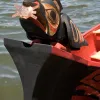 With the sun in its beak, the canoe’s raven figurehead points the way.