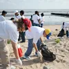 A group of students pick up trash along the coast of Guyana during the Ocean Conservancy's 2012 Coastal Cleanup.