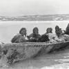 a group of inuit in a large skin boat