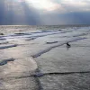 A surfer waits for the perfect wave. 