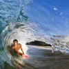 A male surfer catching a wave in Hawaii