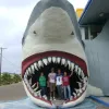 Students pose in the mouth of a giant model of a shark.