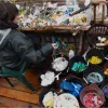 A volunteer sorts washed plastic collected from the beach into buckets by color and size. 