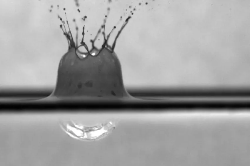 A raindrop falls into a surface oil slick treated with chemical dispersant. A raindrop falls into a surface oil slick treated with chemical dispersant.