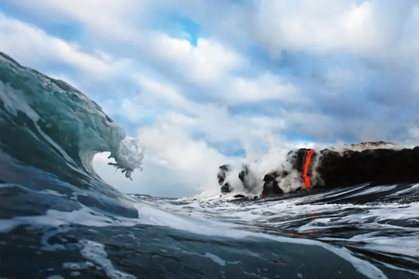 “In 2010, I became the first photographic artist to ever photograph lava from inside the surf. I waited five years for the conditions to be perfect for this type of shot. First, the lava had to cross the beach where most of the coast is a rugged cliff. T