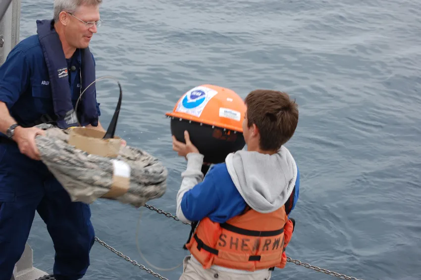 A student helps deploy one of his school's adopted drifters for NOAA's Adopt a Drifter Program.