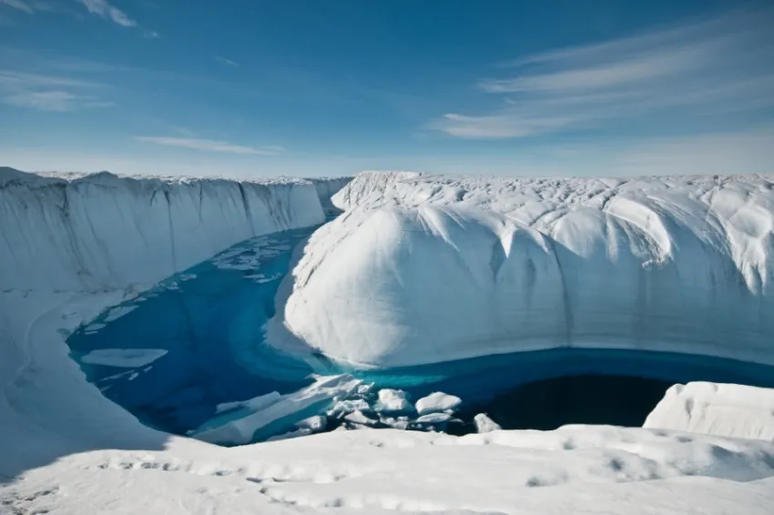 A summertime channel carries melted ice to the sea. Antarctica and Greenland lose around 350 billion tons of ice each year from such melting.