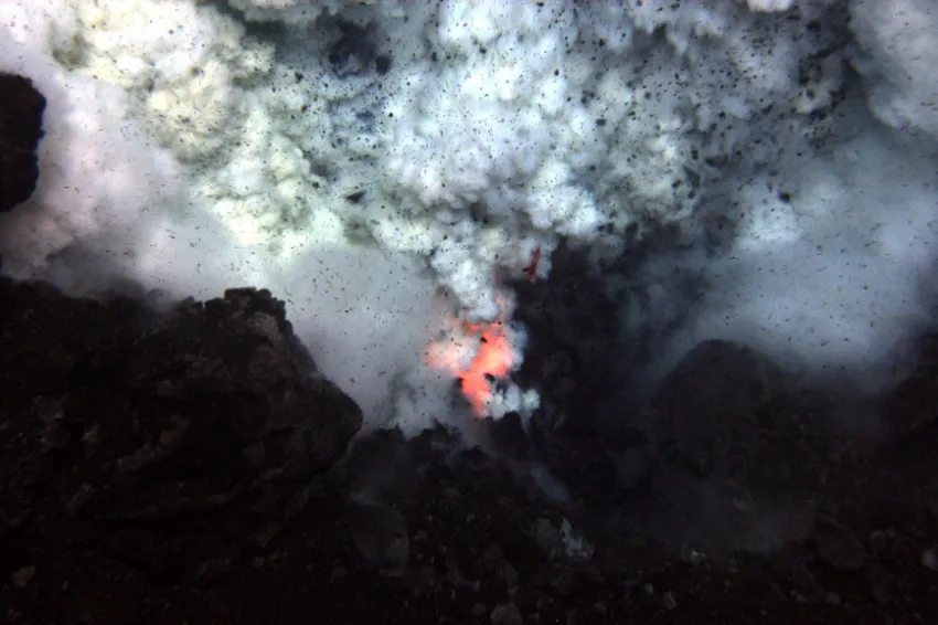 Red hot magma and ash erupt from an underwater volcano.