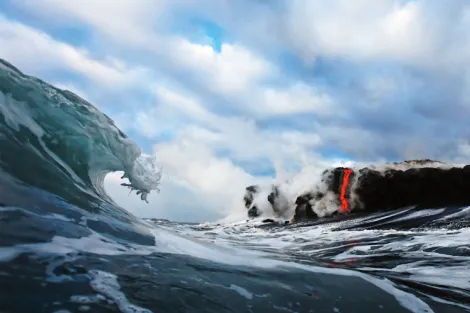 “In 2010, I became the first photographic artist to ever photograph lava from inside the surf. I waited five years for the conditions to be perfect for this type of shot. First, the lava had to cross the beach where most of the coast is a rugged cliff. T