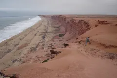 Sandy cliffs of coastal Angola with waves crossing on the shore. 
