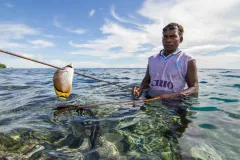 a spear fisher with a speared tropical fish