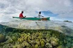 Two fishers in a canoe fishing