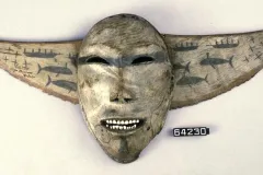 This mask sits atop a decorative breastplate with images of whaling crews in skin boats called umiaks.