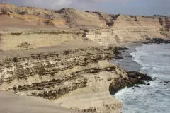 A photo of an arid ocean cliff in Chile's Atacama Desert with the ocean below.