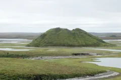 Geologist Charles Paull (Monterey Bay Aquarium Research Institute) investigates geologic features similar to pingos on the Arctic Ocean floor where methane bubbles through sediments and forms hundreds of low hills. On land, a pingo is a place where permafrost bulges beneath a dried lake bed like this one in northern Canada.