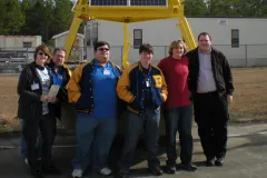 Students studying climate change pose for a photo at a NOAA facility.