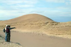 Two researchers, looking for fossil whales, scan a rock formation in Peru's Pisco Basin.