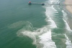 a rip current along a beach with a pier
