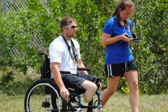 A wounded warrior and a SCUBAnaut practice compass navigation in a field. 