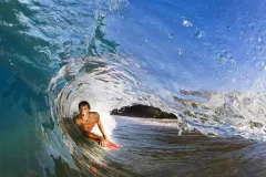 A male surfer catching a wave in Hawaii