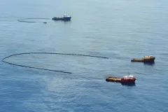 boats sweeping up the oil slick