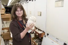 a woman holding a coral specimen