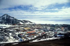 A view of McMurdo Station with a frozen Ross Sea in the background.
