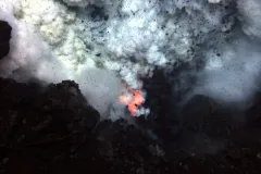 Red hot magma and ash erupt from an underwater volcano. 