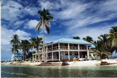 a blue building with wrap around porches on a tropical island
