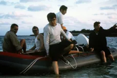 a man exits a small boat full of people