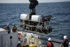 a remotely operated vehicle gets lowered onto the deck of a research vessel