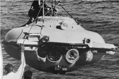 a small submarine hangs from a crane