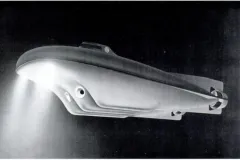 a futuristic and sleek submersible shines a light into the dark sea