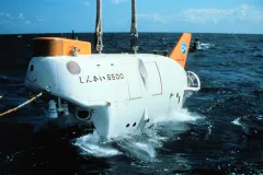 a white submersible is lifted from the ocean