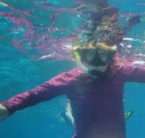 Jennifer Collins wearing snorkel gear underwater.