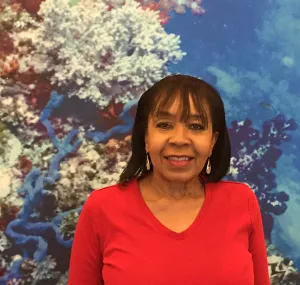 Headshot of Linda Cole with coral reef banner in background.