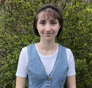 a young woman with a white t shirt and denim vest