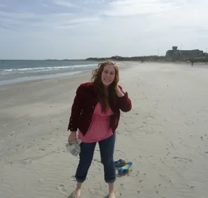 Caty Fairclough standing on a sandy beach.