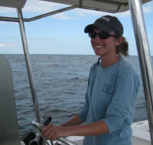 Kristina Cammen driving a boat at sea.