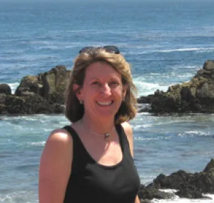 Dawn Martin on the beach with the ocean in the background.