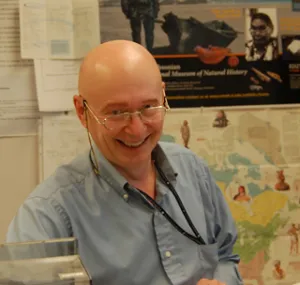 Igor Krupnik sitting at a desk and smiling. 
