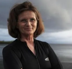 Nancy Knowlton smiling at camera with ocean in background.