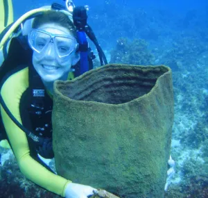 Amber Stubler scuba diving and holding a bag underwater.