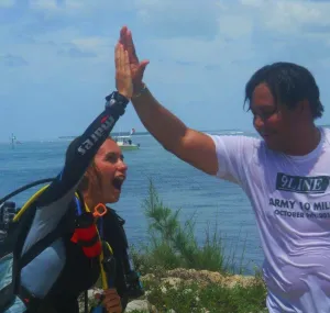 Jessica Silk in SCUBA gear high-fiving a participant in the Combat Wounded Veteran Challenge.