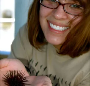 Maria Robles Gonzalez smiling and holding a sea urchin.