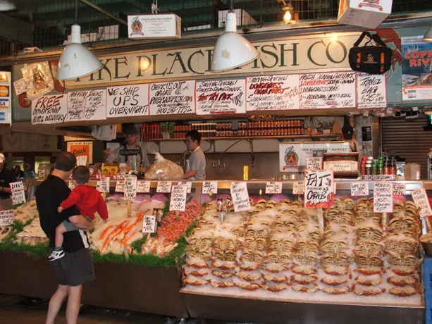 Seafood vendor at historic Pike Place Market in Seattle, Washington (USA). The market draws both shoppers and gawkers who come to watch the gregarious crew of fishmongers.