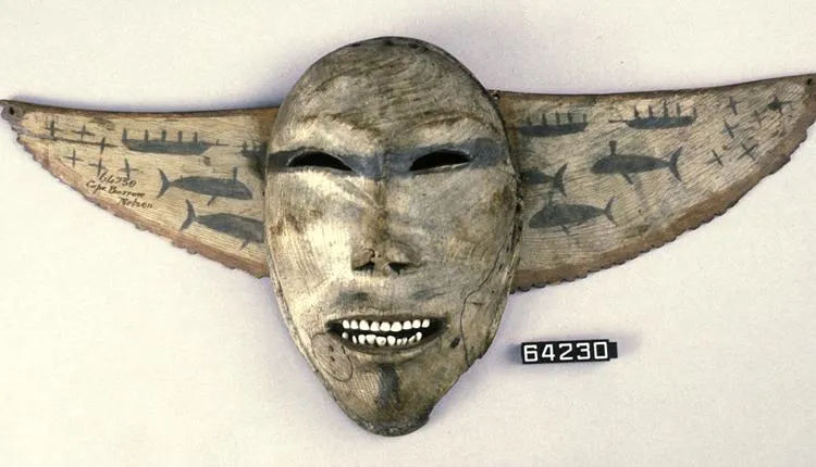 This mask sits atop a decorative breastplate with images of whaling crews in skin boats called umiaks.