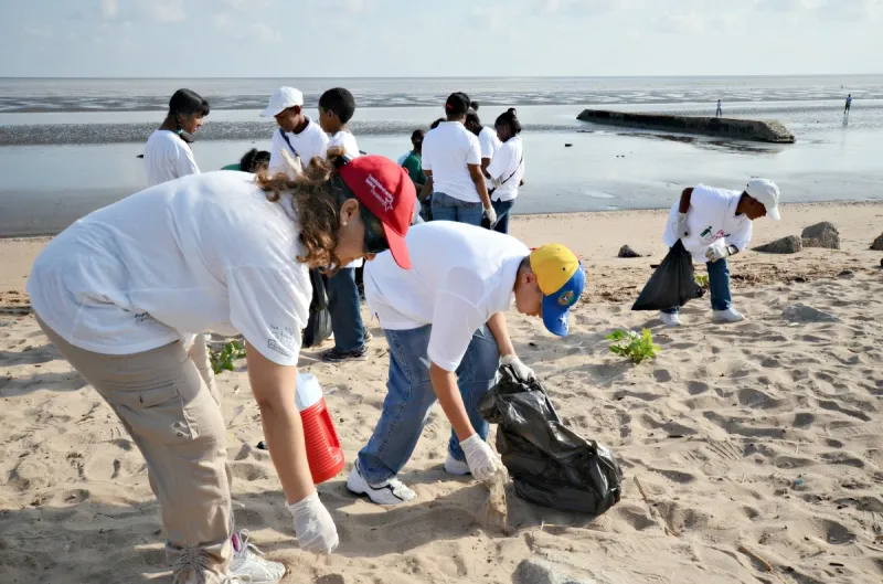 A group of students pick up trash along the coast of Guyana during the Ocean Conservancy's 2012 Coastal Cleanup.