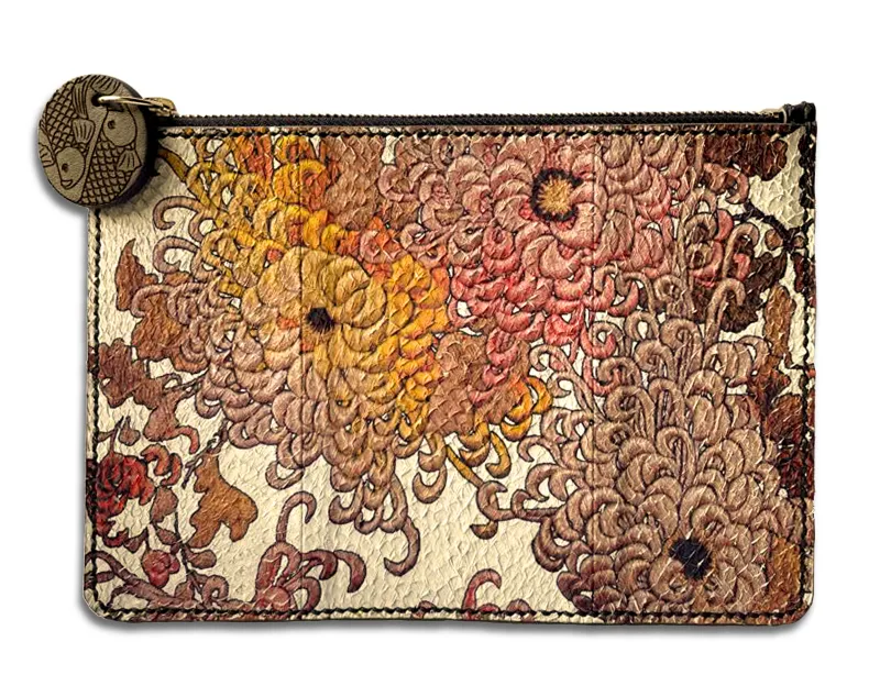 A clutch bag made from fish leather with orange, white, and pink chrysanthemum designs.